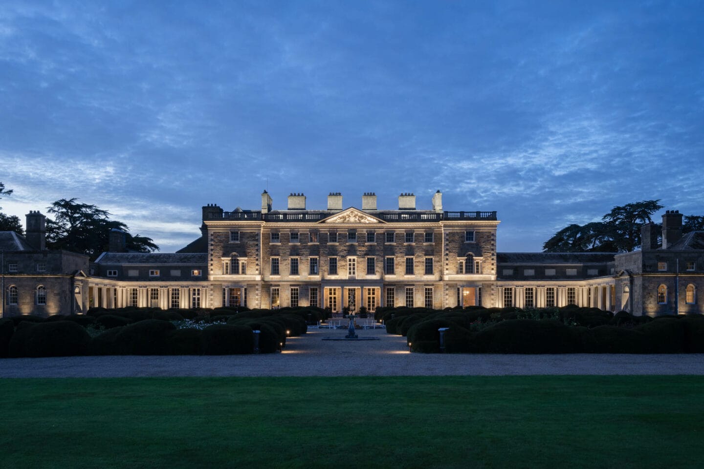 Carton House facade lit at dusk, seen across the lawn