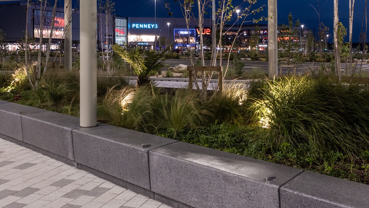 Planting and paving beside the Liffey Valley bus plaza at night