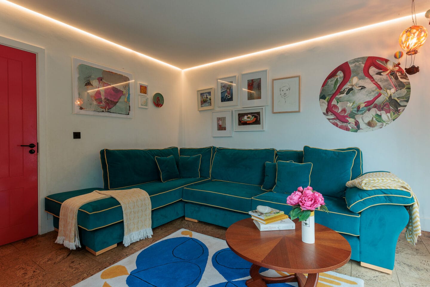 Living room with warm cove lighting and a teal sofa, residential lighting by Willie Duggan