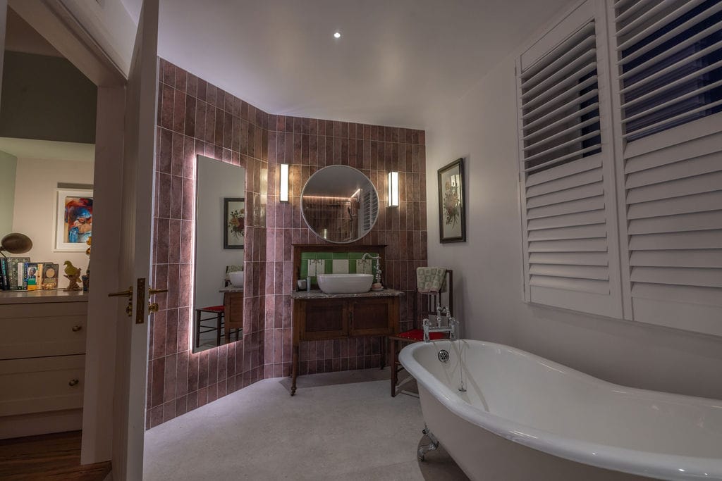 Bathroom with freestanding bath and mirror light in a 1950s terrace house